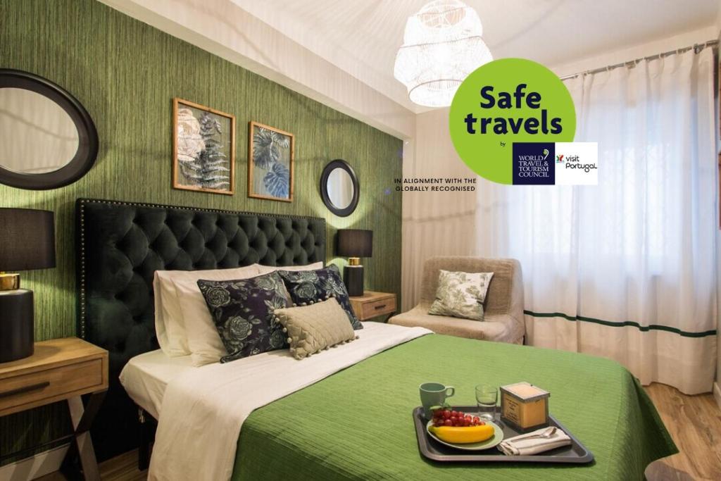 een groene slaapkamer met een bed met een dienblad met eten erop bij Oásis - 82689AL in Lissabon