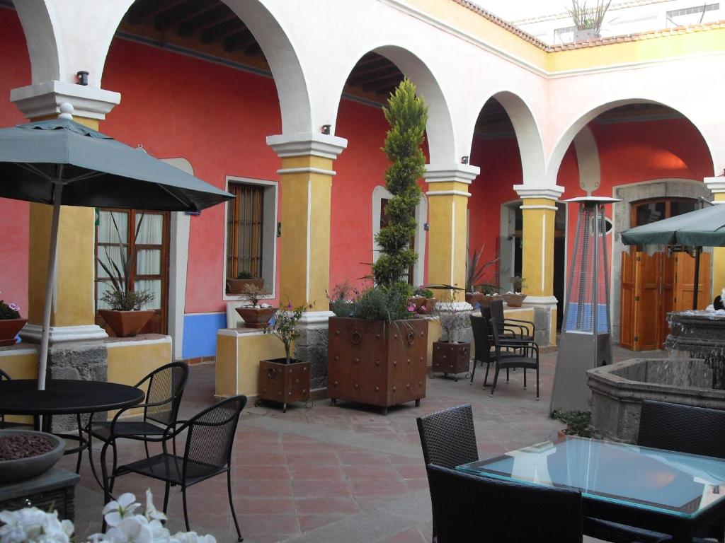 a patio with tables and chairs in a building at Hotel Malinalli in Huamantla