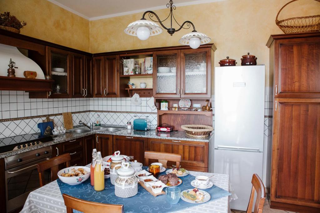 a kitchen with a table and a white refrigerator at la casetta del tesoro in Falconara Marittima