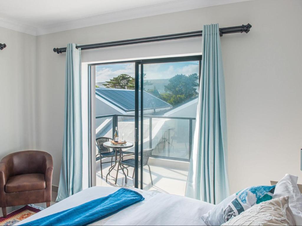 a bedroom with a bed and a view of a balcony at Elizabeth House in Hermanus
