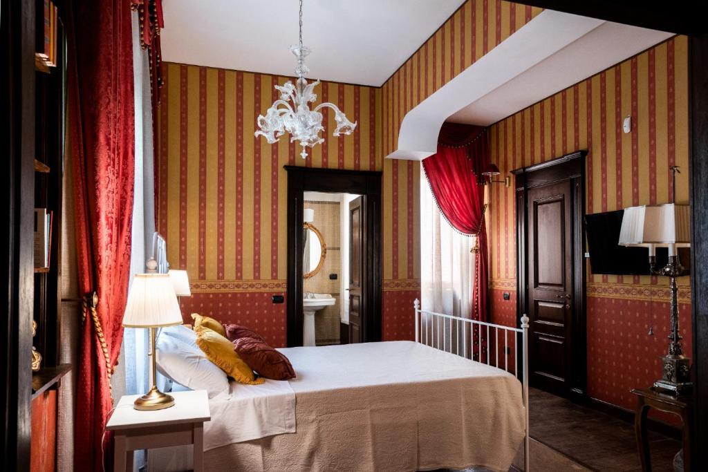 1 dormitorio con cama y lámpara de araña en Palazzo Chiara, en Cagliari