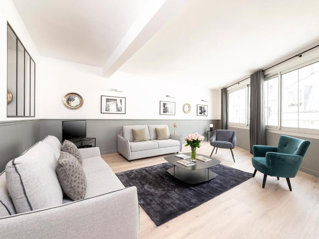un salon avec un canapé blanc et une table dans l'établissement LivinParis - Luxury 3 Bedrooms Le Marais III, à Paris
