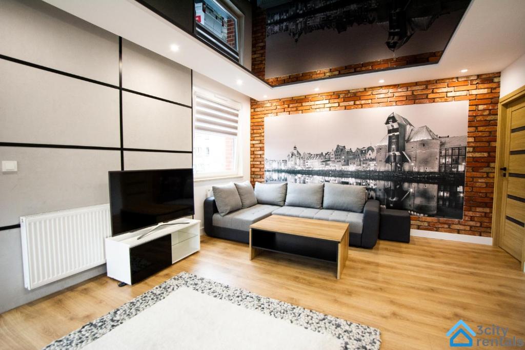 a living room with a couch and a tv at Apartment Showtime Gdańsk in Gdańsk