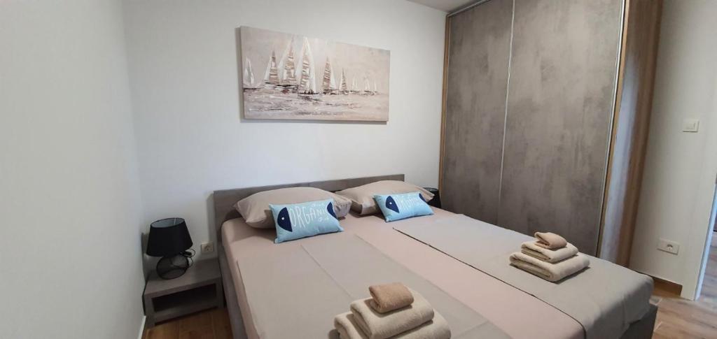 a bedroom with a bed with two pillows on it at Apartmani Tisno TM in Tisno