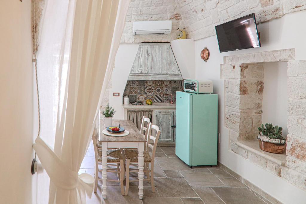 a kitchen with a table and a green refrigerator at Domus Petra civico 104 in Ceglie Messapica