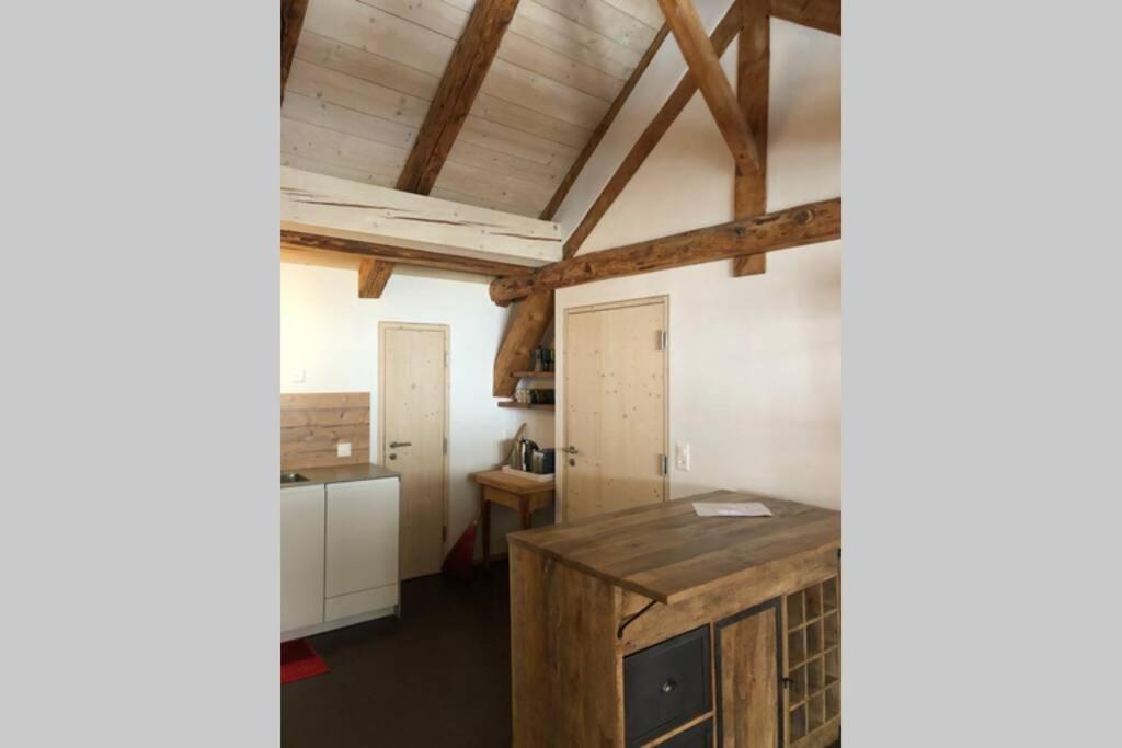 una cucina con isola in legno in una camera di Loft 100m2, im Ökohaus in Susch a Susch