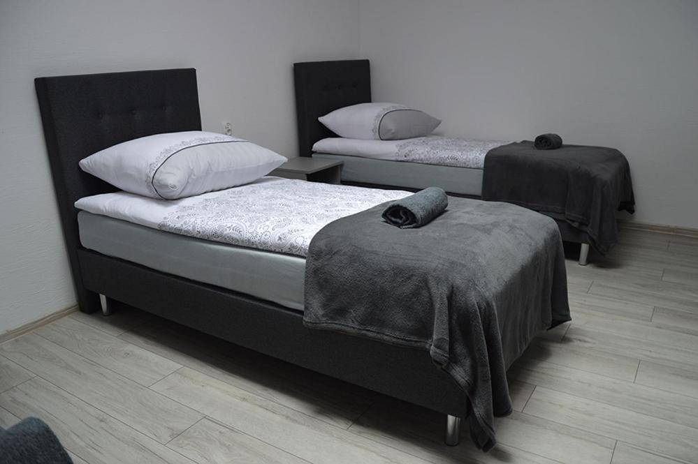 two twin beds in a room with at Hostel Adabet in Kępno