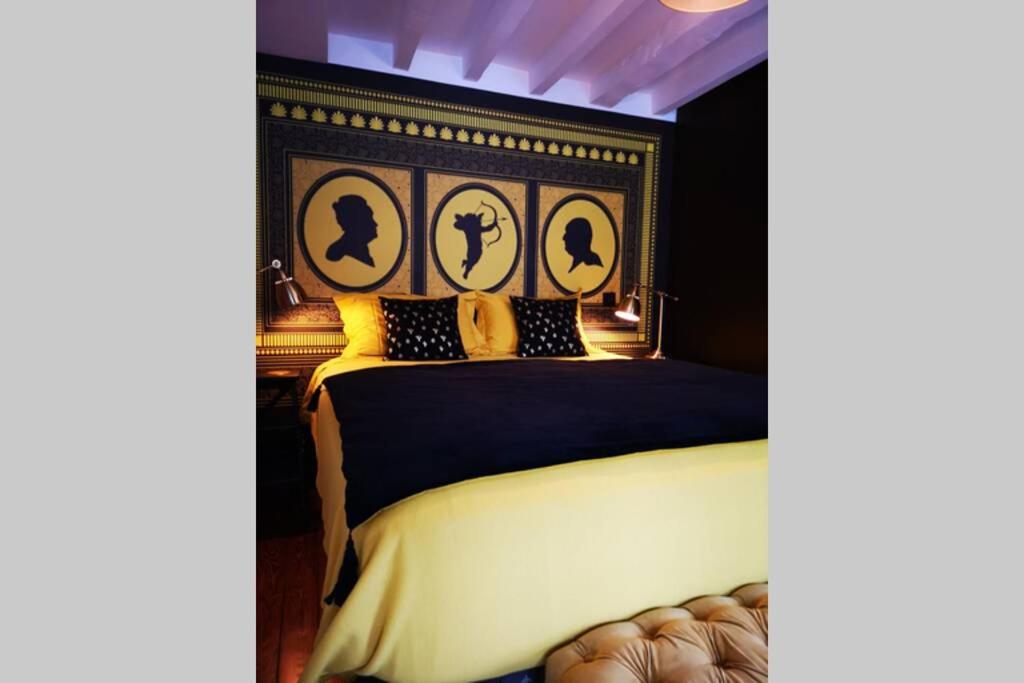 a bedroom with a bed with a black and gold headboard at Le Boudoir in Lyon