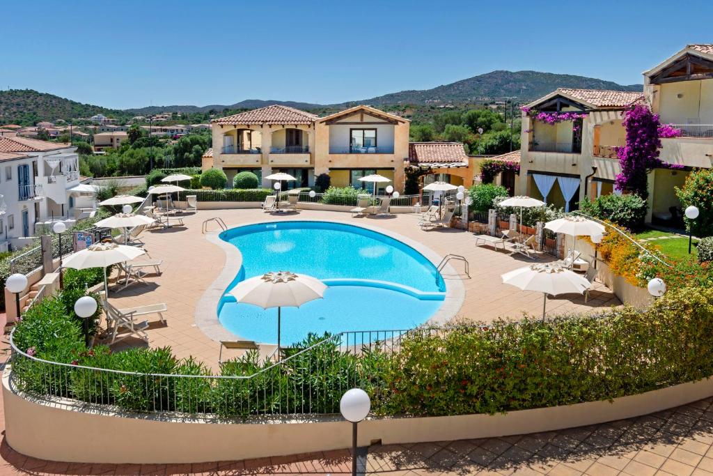 a view of a swimming pool with umbrellas and buildings at Villaggio Turchese in Murta Maria