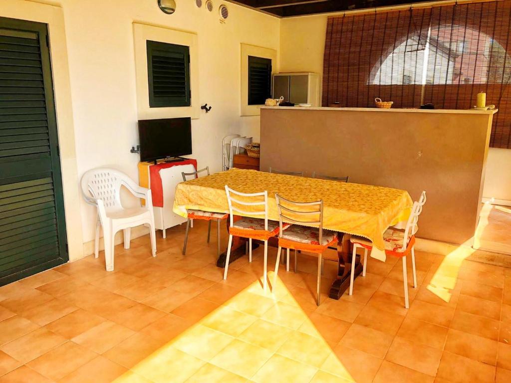 comedor con mesa y sillas en Casa 'Zia Lucia' in Demetra Village, Policoro, en Policoro