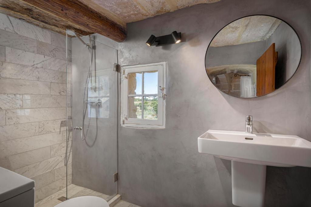 a bathroom with a sink and a mirror at Razzett Ghasri in Għasri