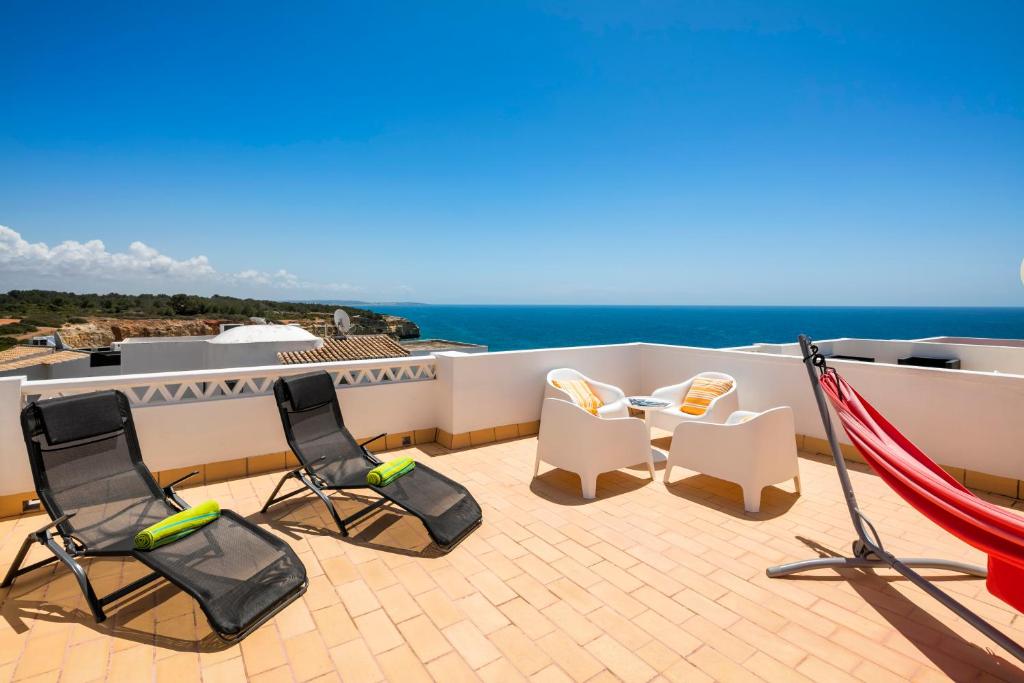 a balcony with chairs and a view of the ocean at Terraços de Benagil 23 (Casa Alvorada) in Benagil