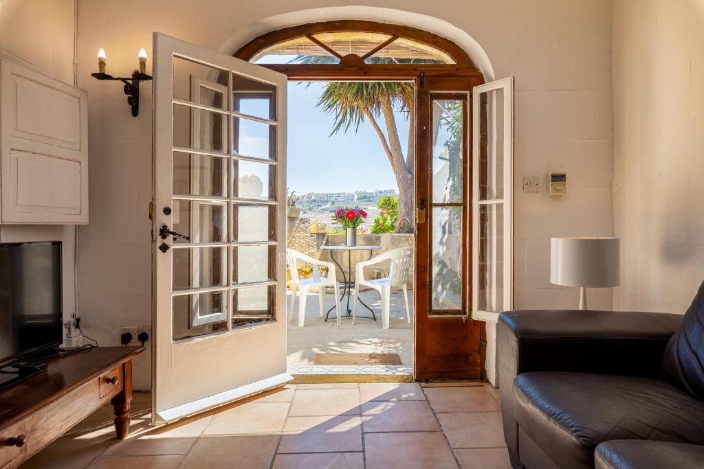 a living room with a door open to a patio at Razzett Ghasri in Għasri