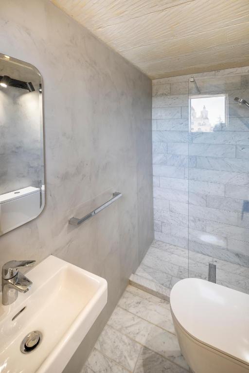 a white bathroom with a sink and a toilet at Razzett Ghasri in Għasri
