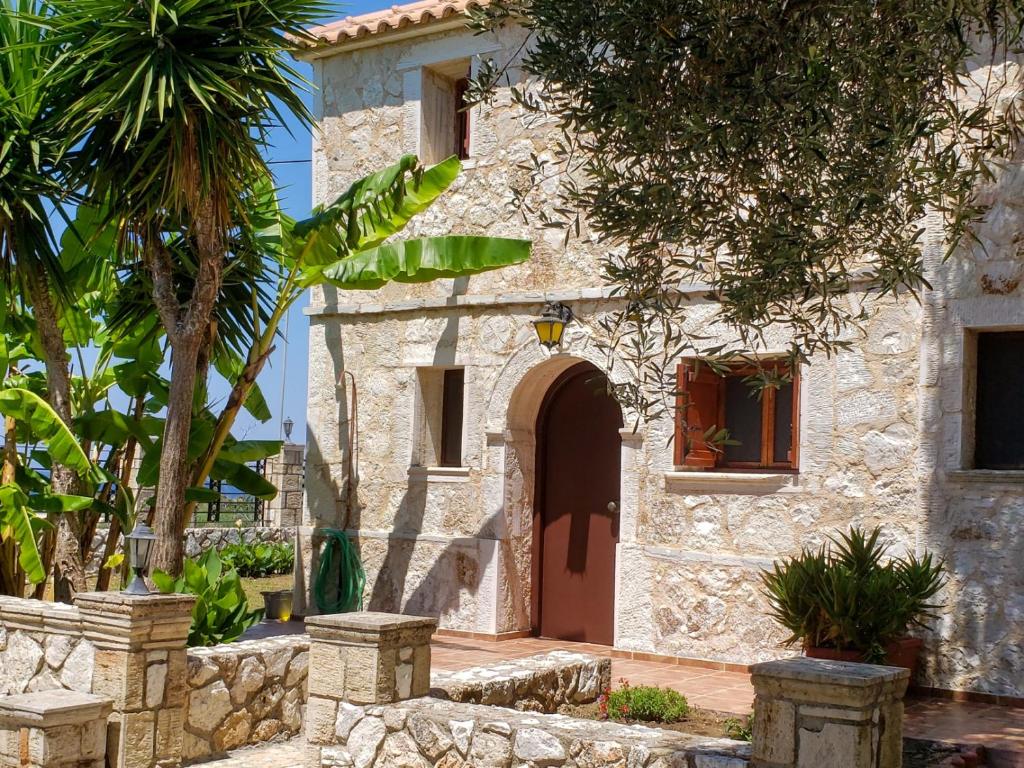 a stone house with a door and a palm tree at Monte e Mare in Minia
