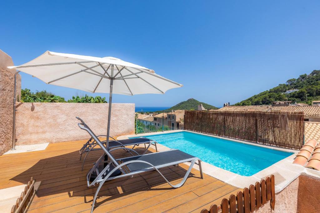 einen Stuhl und einen Regenschirm neben einem Pool in der Unterkunft Can Binitu in Capdepera