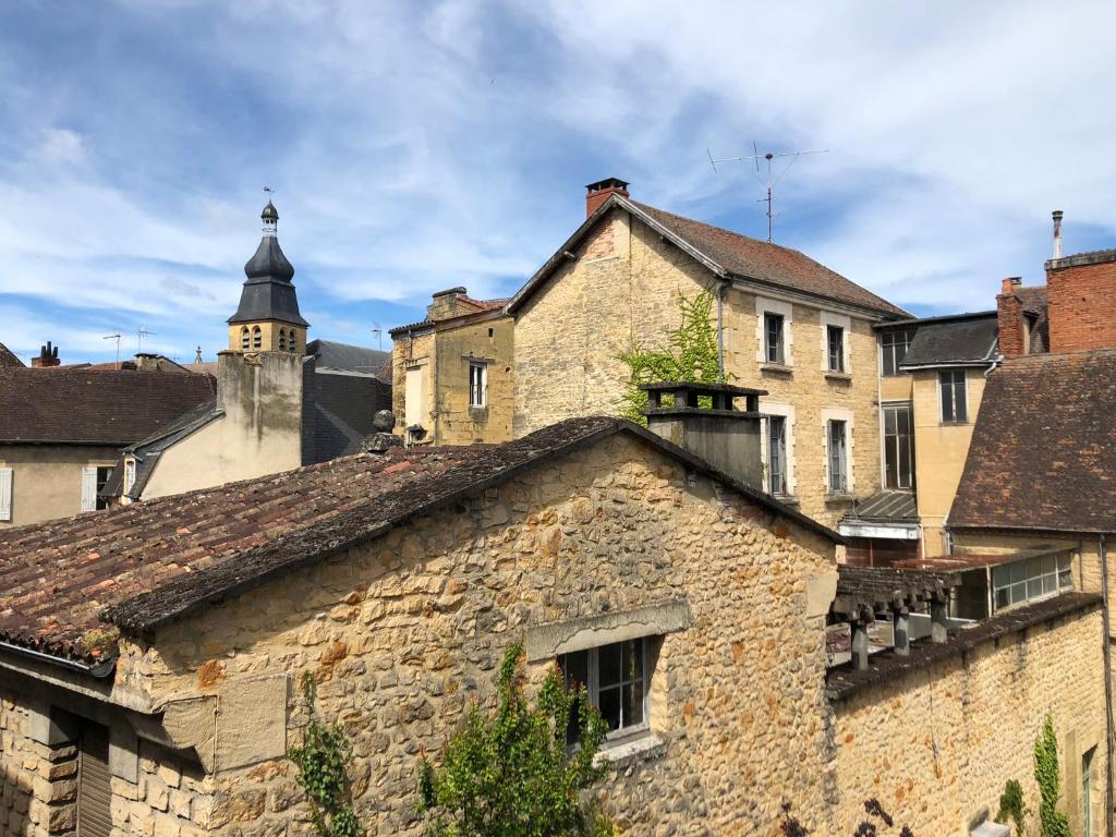 un ancien bâtiment en pierre avec une tour d'horloge en arrière-plan dans l'établissement Les Appartements Chambon, à Sarlat-la-Canéda