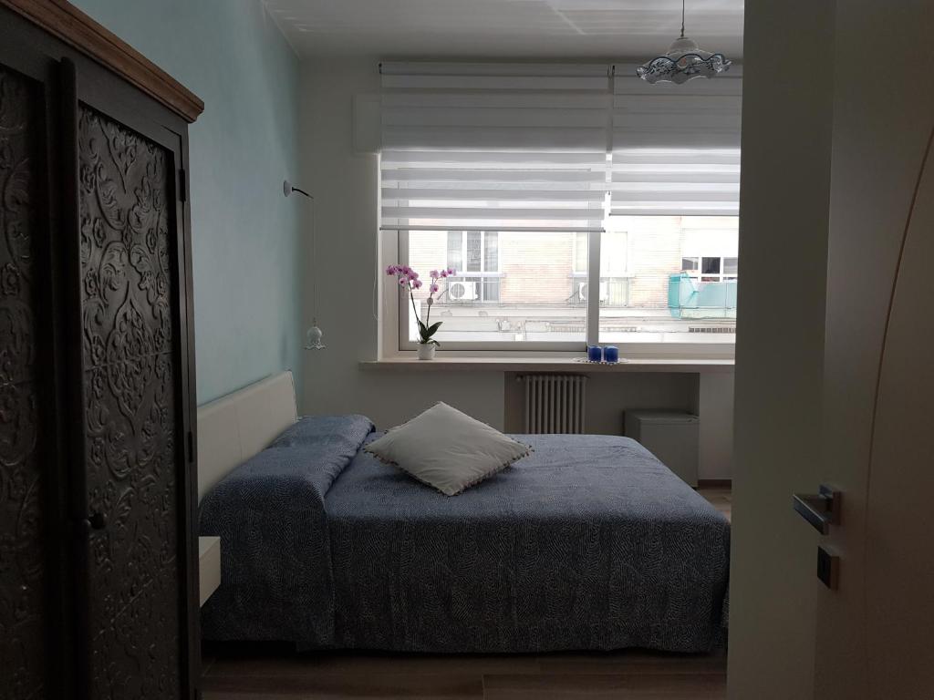 a small bedroom with a bed and a window at RosAmar in Bari