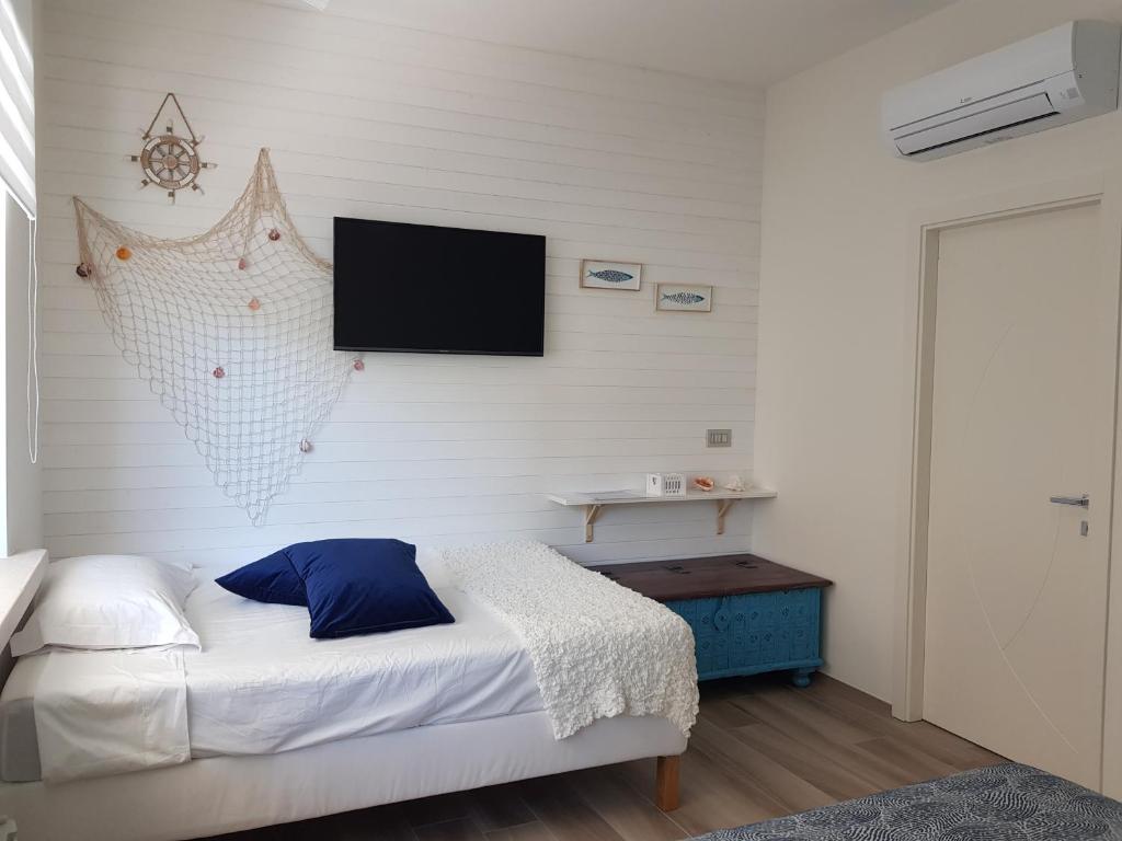 a bedroom with a bed and a flat screen tv on the wall at RosAmar in Bari