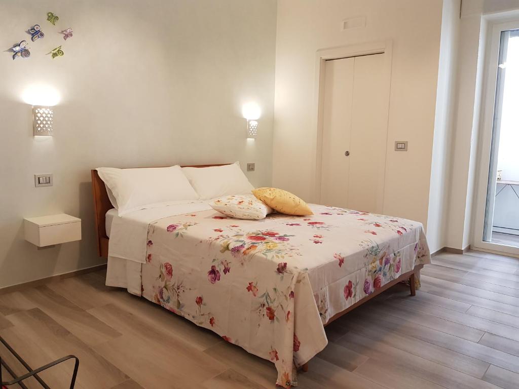 a bedroom with a bed with a floral blanket on it at RosAmar in Bari