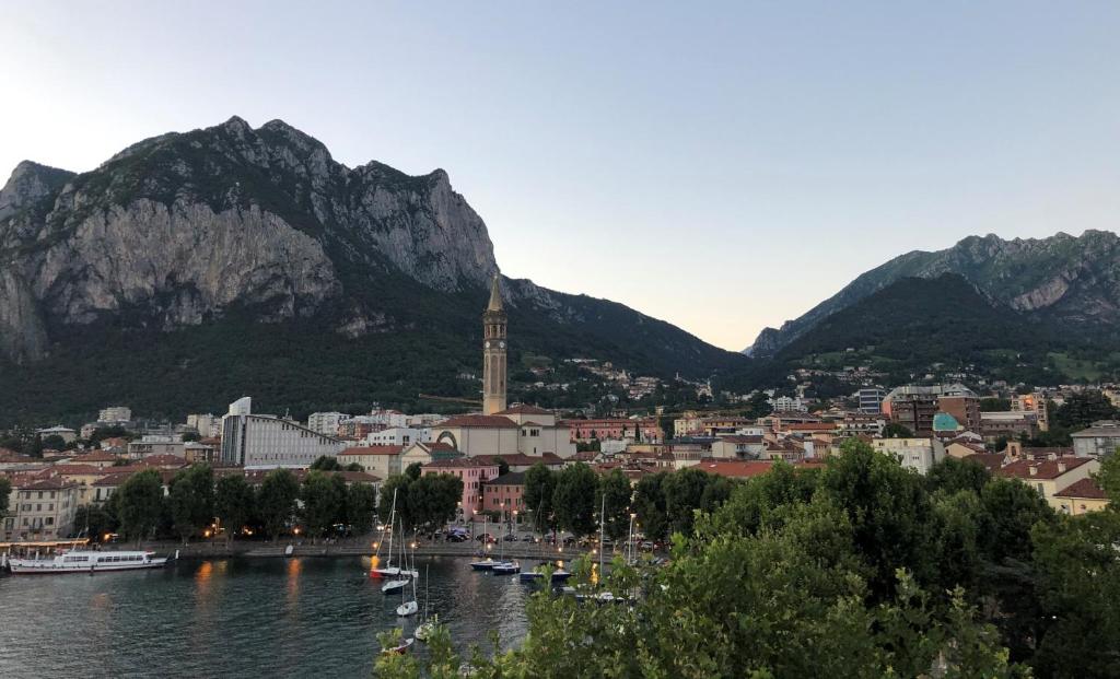 uma cidade com uma cidade e montanhas ao fundo em Hotel Alberi em Lecco