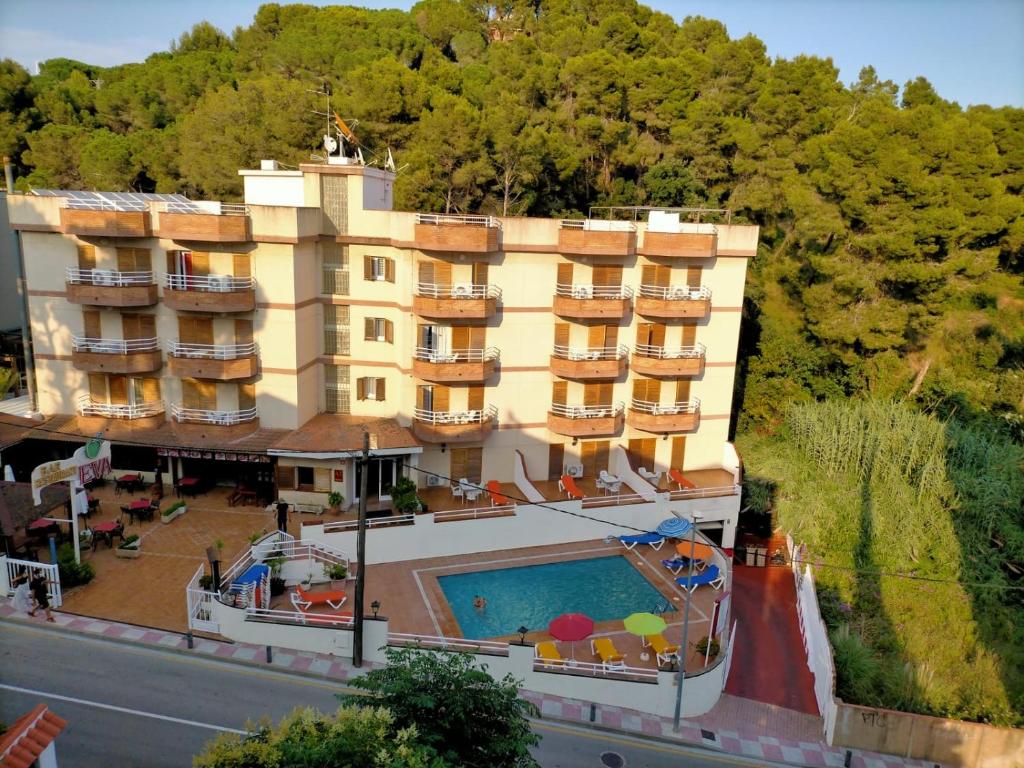 a hotel with a swimming pool in front of a building at Eva Aparthotel in Lloret de Mar