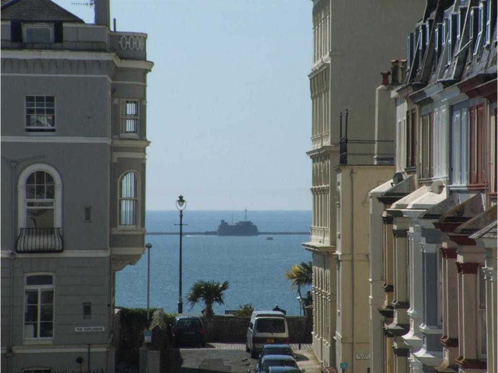 a street with buildings and a ship in the water at LAMPLIGHTER GUESTHOUSE in Plymouth