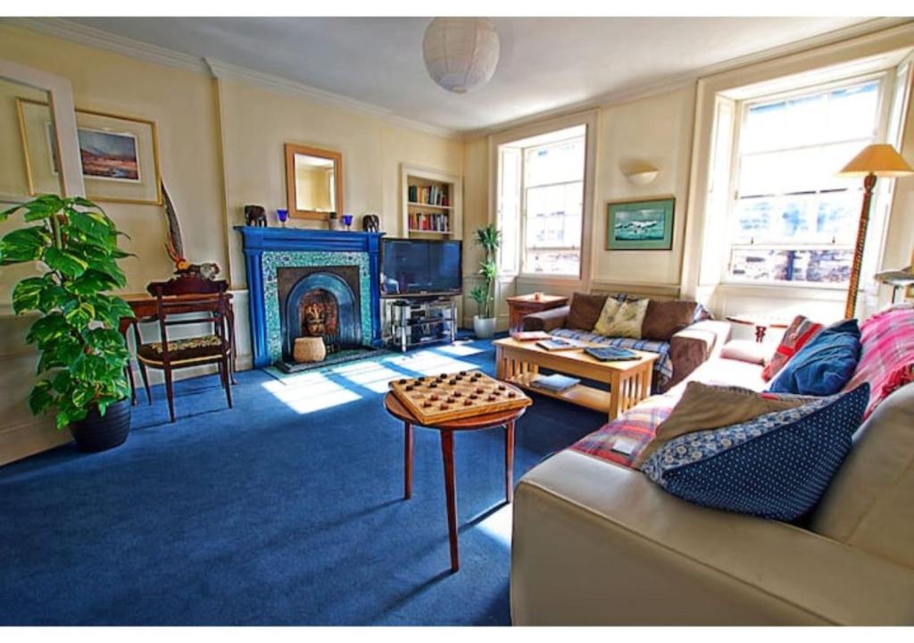 uma sala de estar com um sofá e uma lareira em ALTIDO Gorgeous 2-bed flat near Edinburgh Castle em Edimburgo