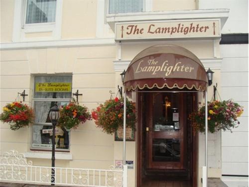 a building with flower baskets on the entrance to a restaurant at LAMPLIGHTER GUESTHOUSE in Plymouth