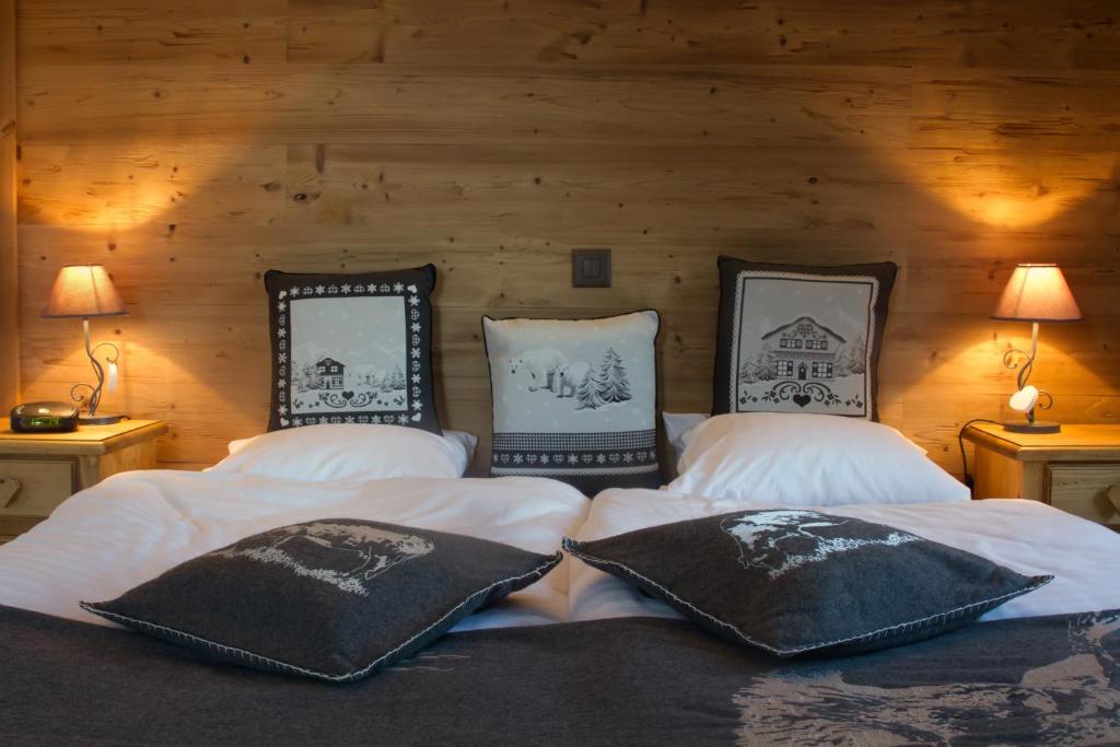 una camera da letto con due letti con cuscini sopra di Hôtel de charme la Poste ad Anzère