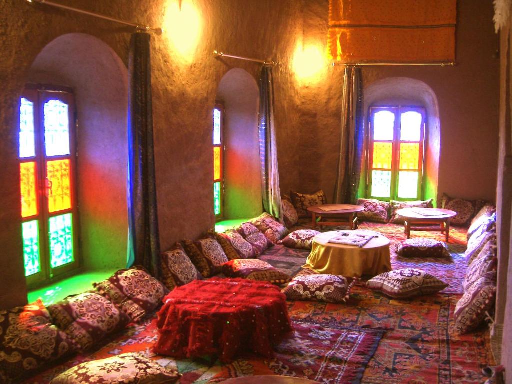 - un salon avec des canapés, une table et des fenêtres dans l'établissement Kasbah Oulad Othmane, à Aguebt