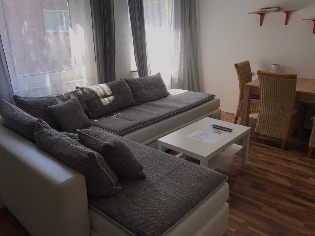 ein Wohnzimmer mit einem Sofa und einem Tisch in der Unterkunft Große Ferienwohnung an der Rheinpromenade three in Duisburg