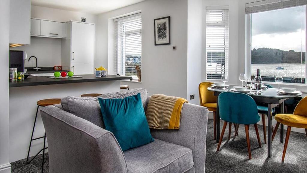 a kitchen and a living room with a table and chairs at Station Approach in Deganwy