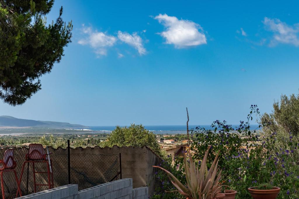 uma vista do jardim de uma casa com duas cadeiras em Casa vacanze i Mandorli em SantʼAnna Arresi