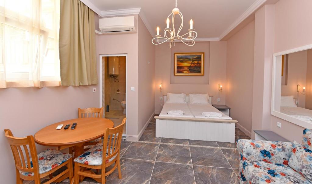 a living room with a table and a bed at Sirena Palace Family Hotel in Obzor