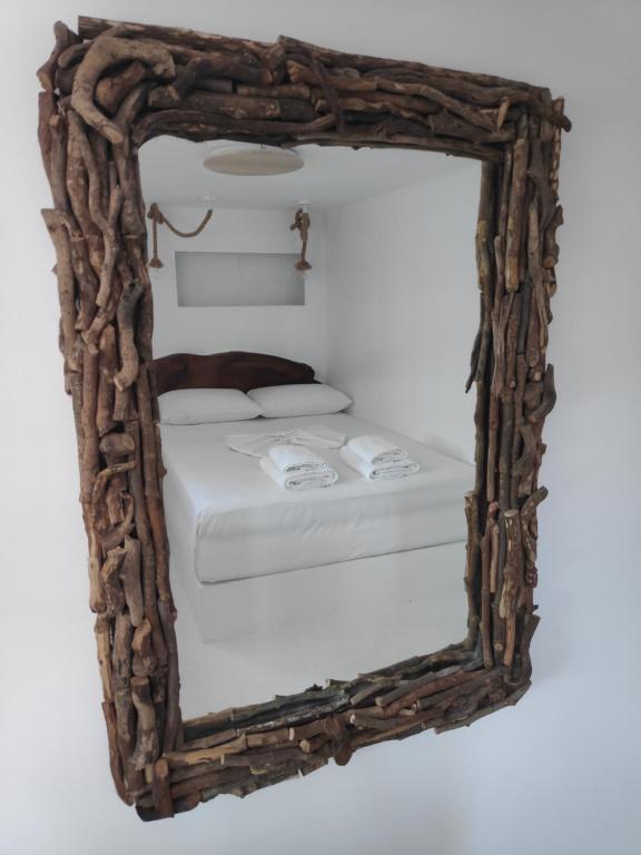 a mirror reflecting a bed in a room at Aletri & Orgoma in Vathi