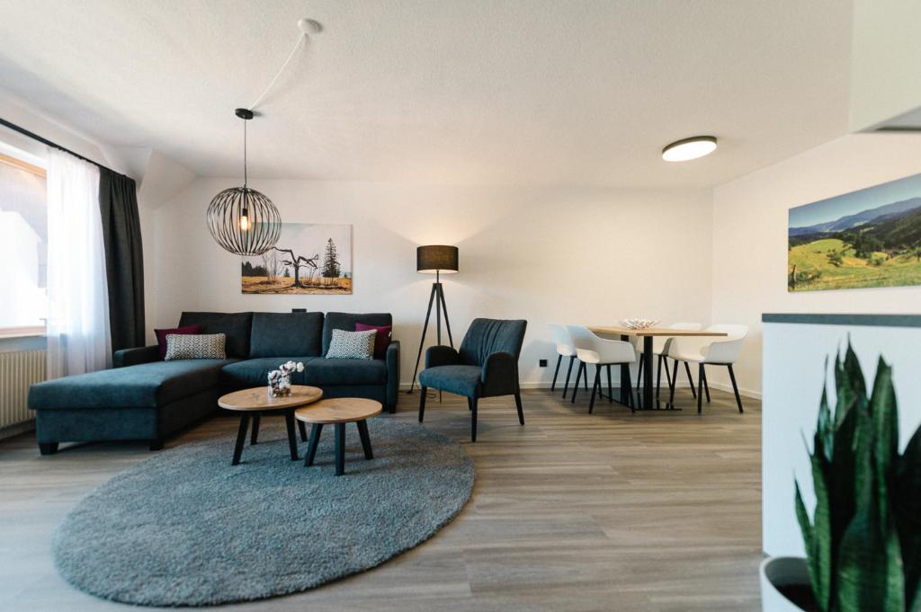 un soggiorno con divano e tavolo di Moderne 3 Zi.-FeWo BlackForest Art Nähe Freiburg a Simonswald