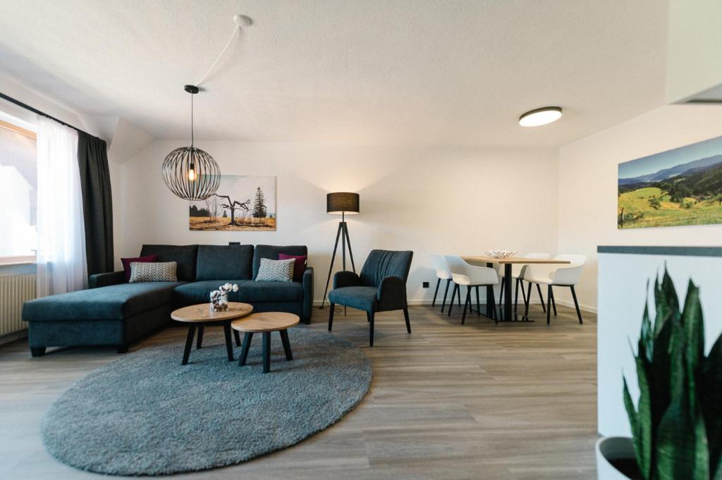 salon z kanapą i stołem w obiekcie Moderne 3 Zi.-FeWo BlackForest Art Nähe Freiburg w mieście Simonswald