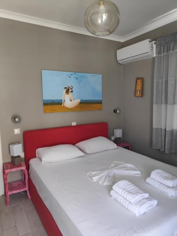 a bedroom with a large bed with a red headboard at Elia & Choma in Vathi