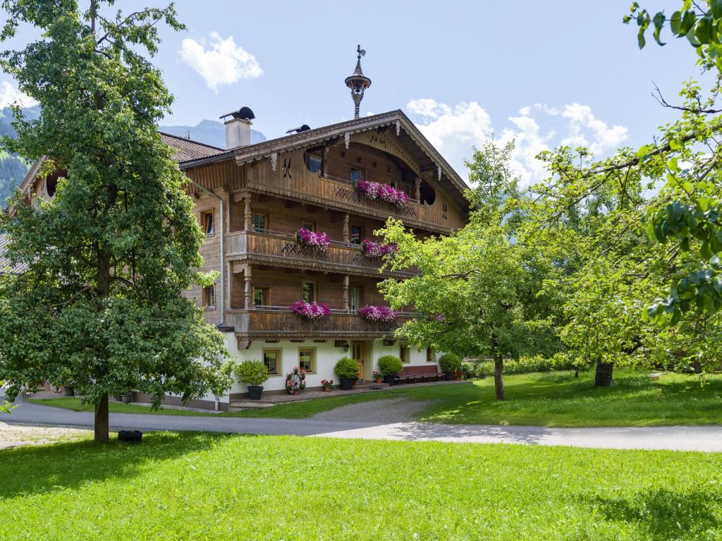 a building with flowers on the balconies in a park at Tuxerhof in Hippach