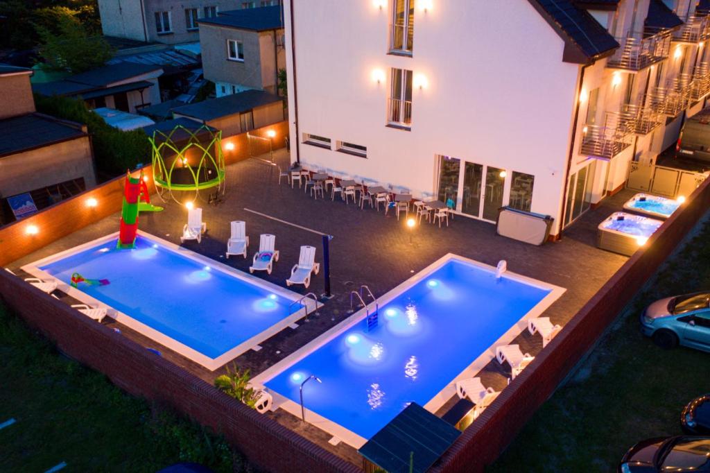 einen Blick über den Pool in der Nacht in der Unterkunft Pod Winogronem - Apartamenty z basenem i wyżywieniem in Pobierowo