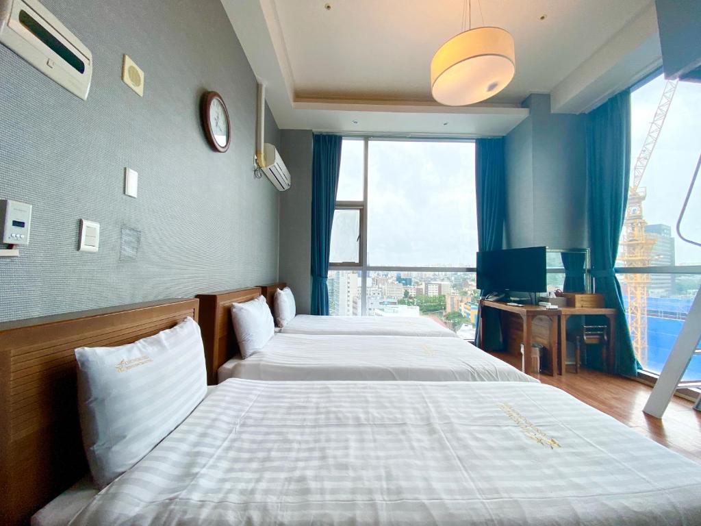 Rúm í herbergi á Myeongdong Merlin Hotel