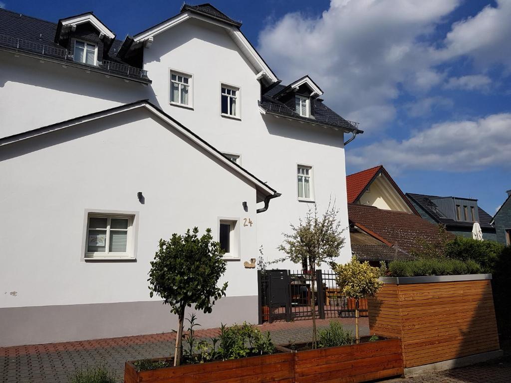 een wit huis met een zwart dak bij Appartement Waldenser in Bad Homburg vor der Höhe