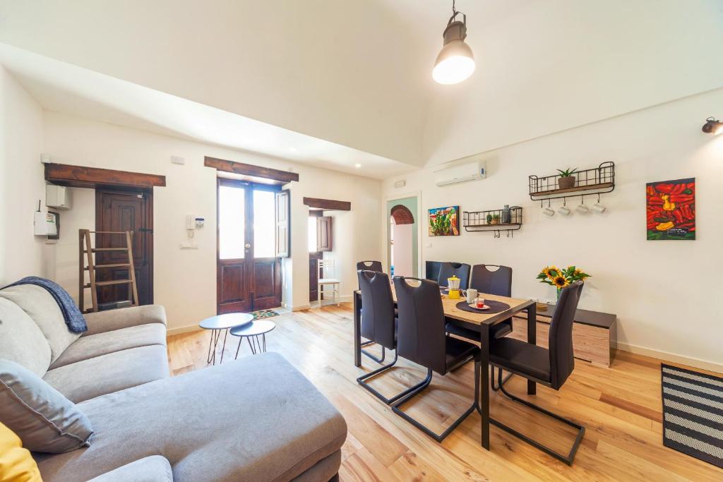 un soggiorno con un divano e un tavolo di GuestHost - Vakalu Piazza Duomo Charming Apartment a Siracusa