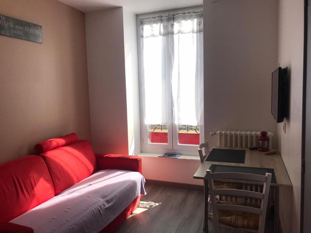 ル・モンドールにあるAppartement face aux Thermesのリビングルーム(赤いソファ、窓付)