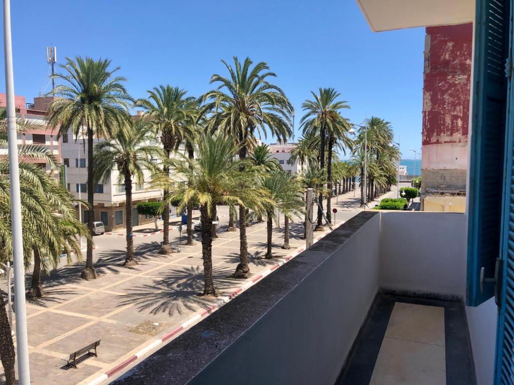 a view from the balcony of a building with palm trees at Hotel El Maghreb Al Kabir in Nador