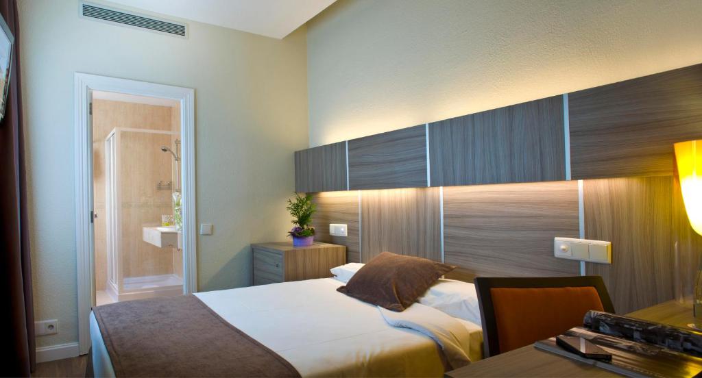 Voodi või voodid majutusasutuse Hotel Serrano toas