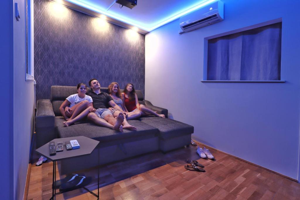 a group of people sitting on a couch in a living room at CinemApartman Eger in Eger
