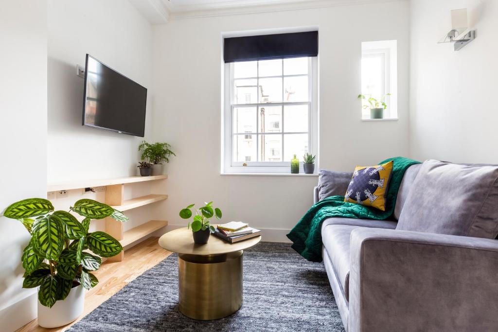 a living room with a couch and a table at Bloomsbury By Viridian Apartments in London