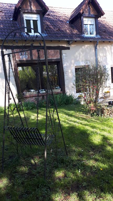 un columpio en un patio frente a una casa en Chez Lydie et Jean Paul en Vignoux-sur-Barangeon